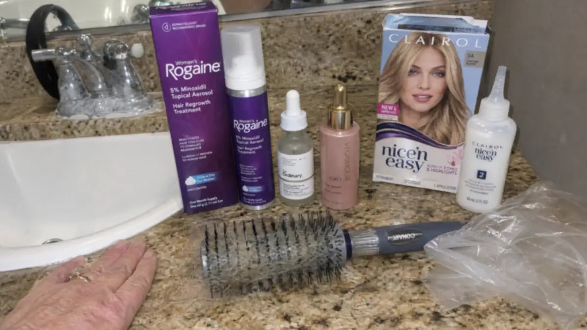 Bathroom counter covered in Rogaine foam, serums, Clairol box dye and brushes — what $3,000 of hair products looks like